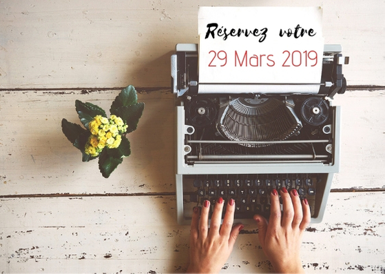 Mains de femme devant une machine à écrire avec un petit pout de fleurs jaunes sur la gauche