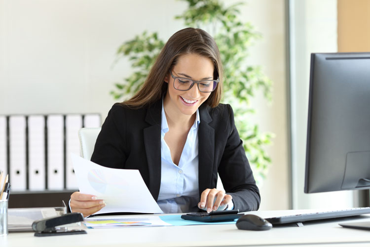 Femme d'affaires avec une calculatrice au bureau