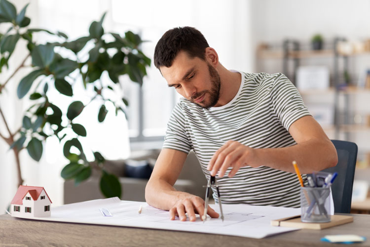 Jeune homme dessine avec un compas