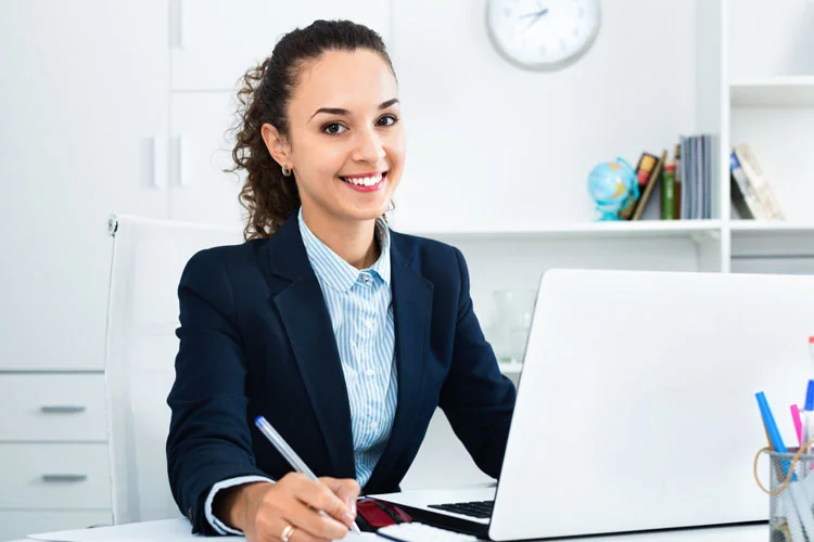 Femme d'affaires assis au bureau avec ordinateur portable
