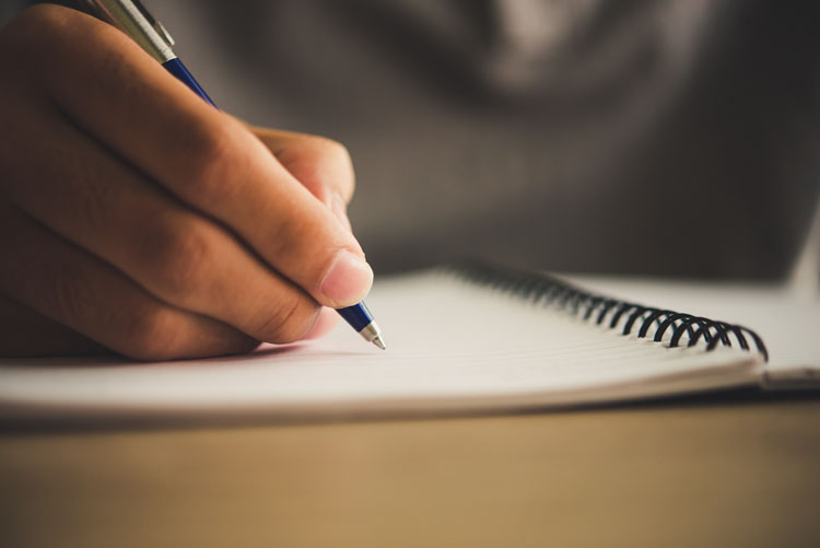 Man hand with pen writing on notebook. homme qui écrit